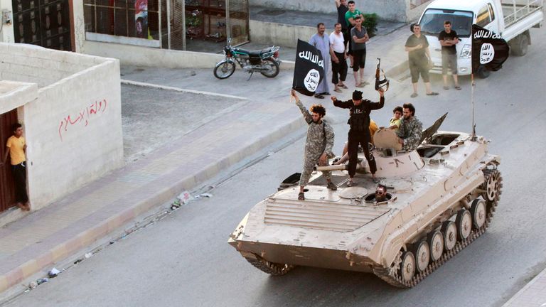 Des combattants de l'État islamique participent à un défilé militaire dans la province de Raqqa en juin 2014