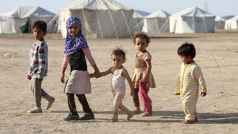 Des enfants marchent dans un camp pour personnes déplacées par les combats dans la province d'Al-Jawf, au nord du Yémen 