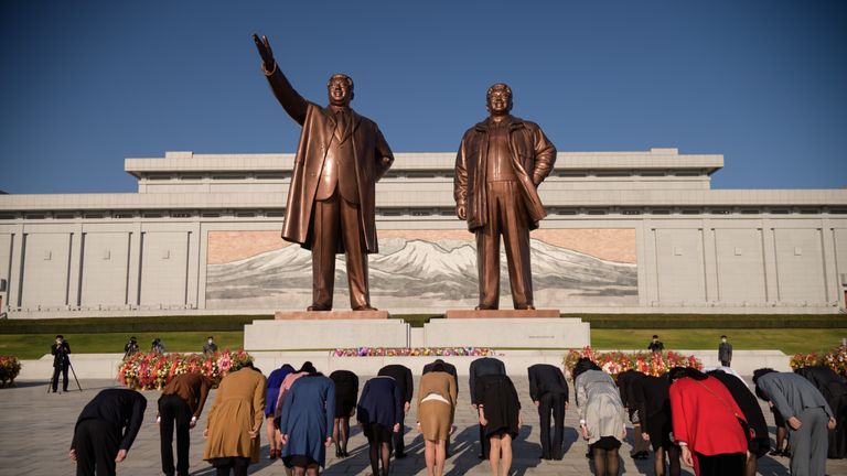 Les gens s'inclinent devant les statues des derniers dirigeants nord-coréens Kim Il Sung et Kim Jong Il sur la colline de Mansu alors que le pays marque le 75e anniversaire de la fondation du Parti des travailleurs de Corée, à Pyongyang le 10 octobre 2020 (photo de KIM Won Jin / AFP) (Photo par KIM WON JIN / AFP via Getty Images)