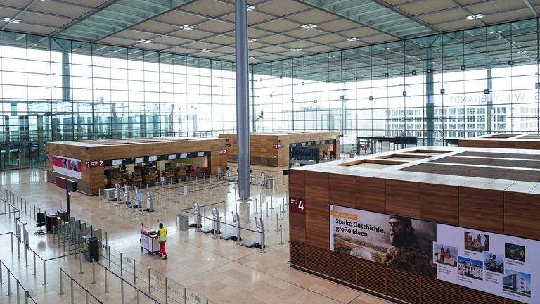 SCHOENEFELD, ALLEMAGNE - 19 OCTOBRE: Un concierge se promène dans le principal hall des départs du nouvel aéroport Berlin Brandenburg BER pendant la pandémie de coronavirus le 19 octobre 2020 à Schoenefeld, Allemagne.  Le nouvel aéroport devrait entrer en service le 31 octobre malgré la forte augmentation actuelle des infections à Covid-19.  L'aéroport desservira à la fois la ville de Berlin et la région environnante.  (Photo par Sean Gallup / Getty Images)