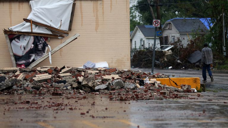 Un homme passe devant un bâtiment qui a été endommagé par l'ouragan Laura à l'approche du delta de l'ouragan à Lake Charles, Louisiane, États-Unis, le 9 octobre 2020