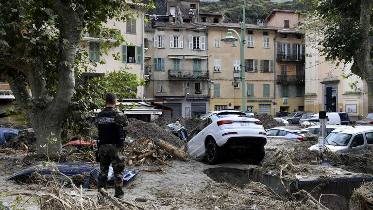 Un gendarme se tient parmi les débris dont des véhicules à Breil-sur-Roya, dans le sud-est de la France, le 4 octobre 2020, après de nombreuses inondations qui ont causé des dégâts importants dans le département des Alpes-Maritimes.
