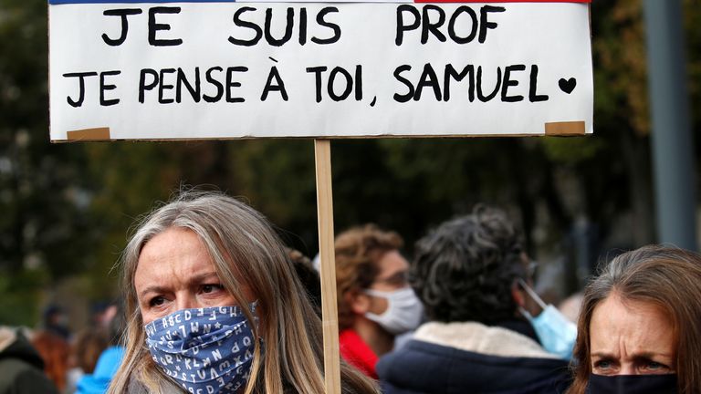 Une femme tient une banderole alors qu'elle assiste à un hommage à Samuel Paty, le professeur de français décapité dans les rues de la banlieue parisienne de Conflans St Honorine, place de la République, à Lille, France, le 18 octobre 2020. REUTERS / Pascal Rossignol

