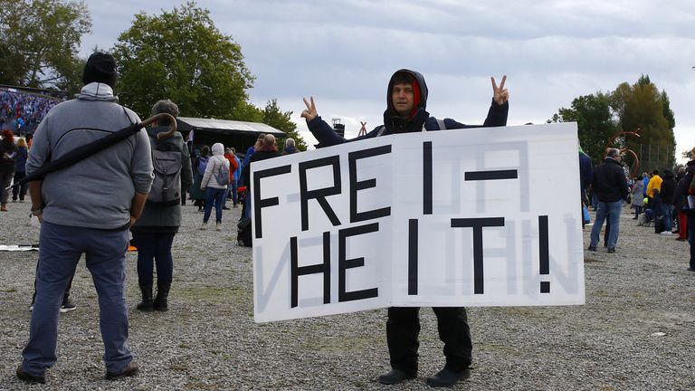 Un homme qui protestait contre les restrictions tenait une pancarte disant `` liberté ''