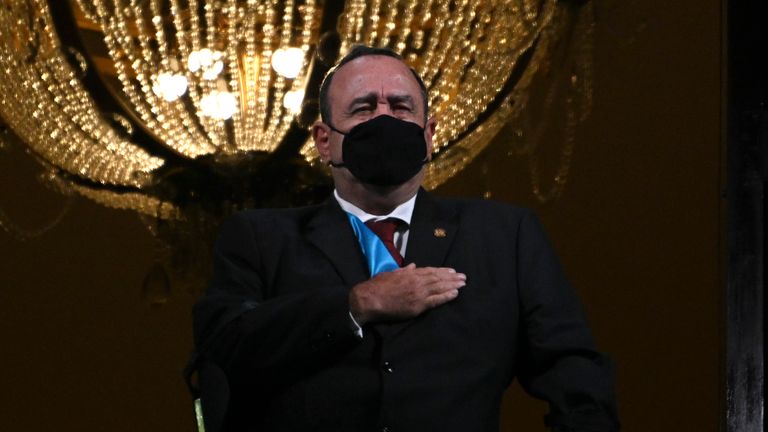 Alejandro Giammattei portant un masque facial, chante l'hymne national lors des célébrations de l'indépendance au début du mois