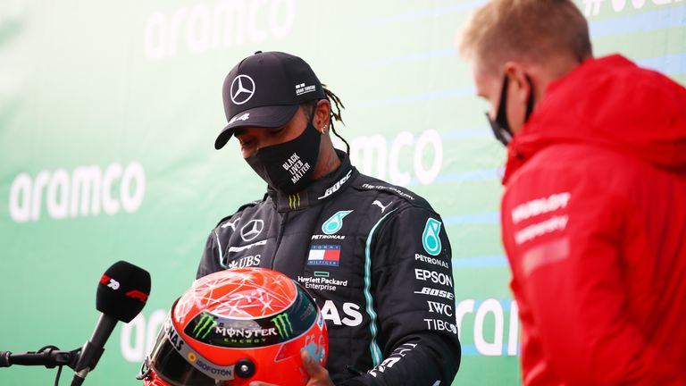 NUERBURG, ALLEMAGNE - 11 OCTOBRE: Le vainqueur de la course Lewis Hamilton de Grande-Bretagne et Mercedes GP est présenté avec un casque de Michael Schumacher par son fils Mick Schumacher d'Allemagne et Alfa Romeo Racing pour avoir égalé son record de 91 victoires lors du Grand Prix F1 Eifel au Nürburgring le 11 octobre 2020 à Nuerburg, Allemagne.  (Photo par Bryn Lennon / Getty Images)
