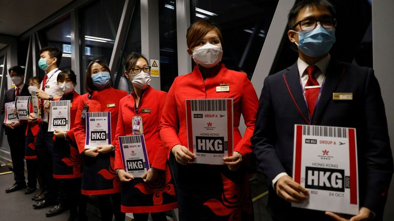 Les équipes au sol tiennent des pancartes pour accueillir les passagers à leur retour de l'Embrace de la compagnie aérienne de Hong Kong 