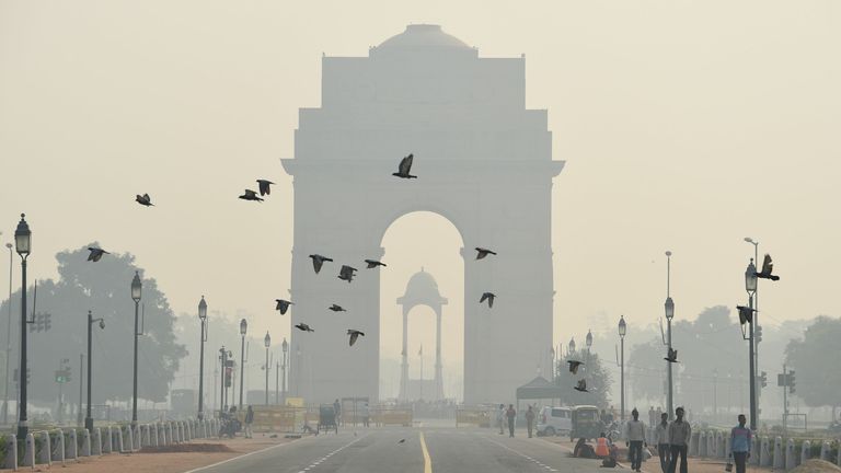 TOPSHOT - Des piétons indiens marchent près du monument de la Porte de l'Inde au milieu du smog intense à New Delhi le 28 octobre 2016. - La capitale de l'Inde, avec 18 millions d'habitants, a l'air le plus pollué du monde, se détériorant en hiver alors que les températures chutent et que les agriculteurs brûlent les champs après la récolte d'été.  (Photo par Dominique Faget / AFP) (Photo par DOMINIQUE FAGET / AFP via Getty Images)
