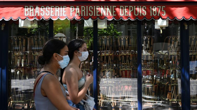 Des femmes portant un masque protecteur passent devant un restaurant fermé à Paris le 30 mai 2020, alors que la France assouplit les mesures de verrouillage prises pour freiner la propagation du COVID-19 (le nouveau coronavirus)