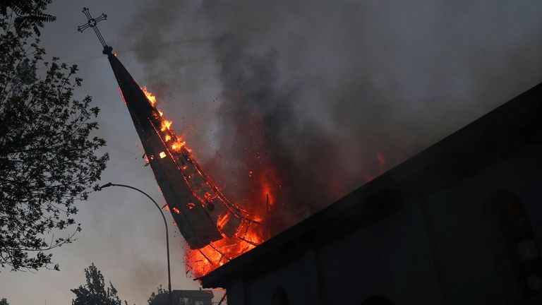 Une flèche d'église en feu tombe au sol après avoir été incendiée dans la capitale chilienne 