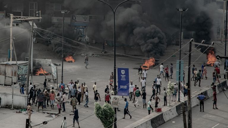 Des gens sont vus près de pneus en feu dans la rue, à Lagos (UnEarthical / via Reuters) 