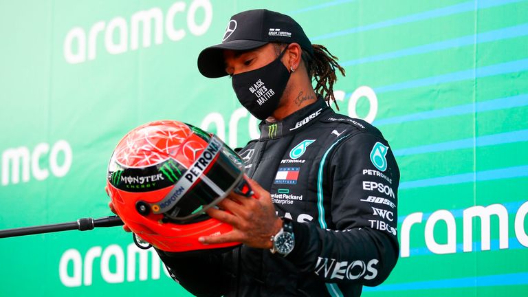 Lewis Hamilton, pilote britannique du vainqueur Mercedes, tient le casque rouge de l'ancien champion allemand de Formule 1 Michael Schumacher qui lui a été offert par Mick Schumacher