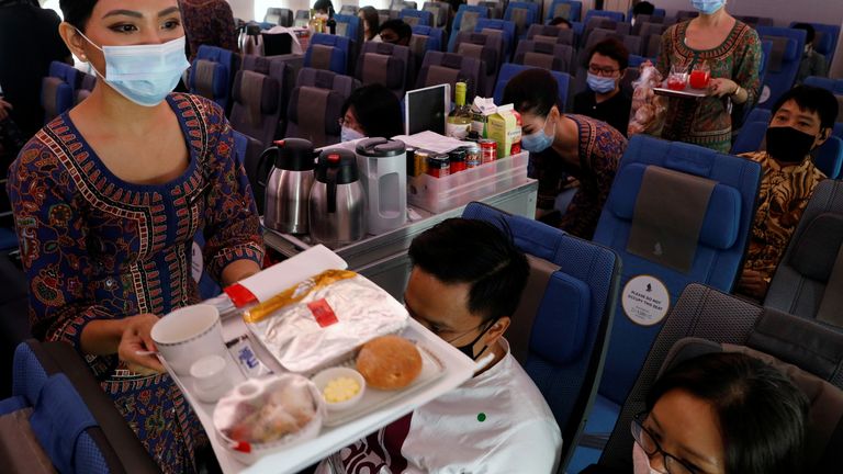 Les hôtesses de Singapore Airlines servent de la nourriture à bord de la cabine en classe économique de leur restaurant A380 à l'aéroport de Changi à Singapour le 24 octobre 2020. REUTERS / Edgar Su