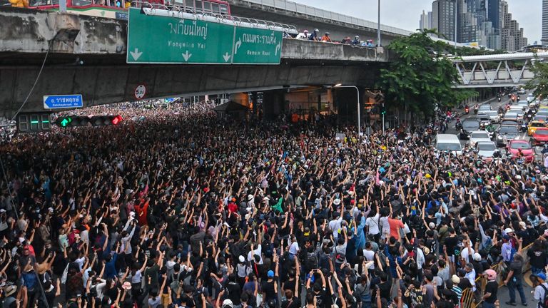 Des manifestants pro-démocratie saluent à trois doigts lors d'un rassemblement antigouvernemental à Bangkok