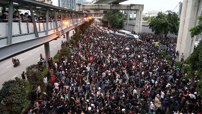 Des manifestants pro-démocratie marchent le long d'une route lors d'un rassemblement antigouvernemental à Udomsuk