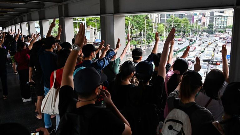 Le salut à trois doigts montré aux automobilistes lors d'un flash mob à la station de métro aérien Asok BTS à Bangkok