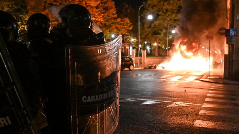 Des policiers montent la garde alors que des manifestants incendient des biens publics lors d'une manifestation anti-gouvernementale 