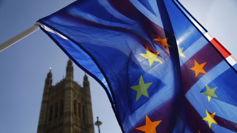 Un activiste agite une combinaison des drapeaux de l'Union et de l'UE près des Chambres du Parlement dans le centre de Londres le 10 avril 2019. - Le négociateur en chef de l'UE sur le Brexit a déclaré mardi que la durée de tout retard au divorce que le bloc pourrait accorder à la Grande-Bretagne serait dépendra du plan que la première ministre Theresa May proposera à un sommet critique.  (Photo de Tolga AKMEN / AFP) (Le crédit photo doit se lire TOLGA AKMEN / AFP via Getty Images)