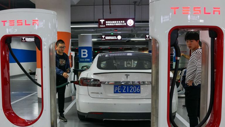 Les gens chargent leurs véhicules Tesla à une station de recharge à l'intérieur d'un centre commercial à Shanghai le 23 octobre 2017. - Tesla a conclu un accord avec les autorités de Shanghai qui en ferait le premier constructeur automobile étranger à construire sa propre usine en Chine, en la plaçant chez le conducteur. siège sur le plus grand marché mondial de véhicules électriques, a rapporté le Wall Street Journal.  (Photo par CHANDAN KHANNA / AFP) (Le crédit photo doit se lire CHANDAN KHANNA / AFP via Getty Images)
