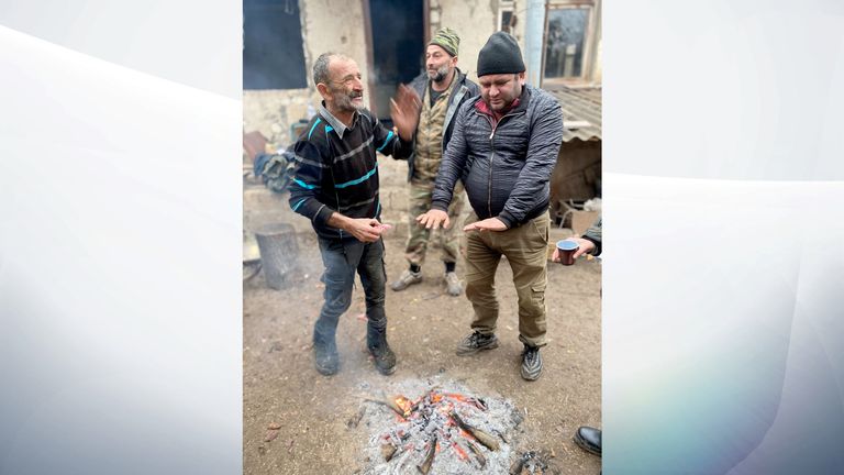 Certains hommes se réchauffent les mains près d'un feu