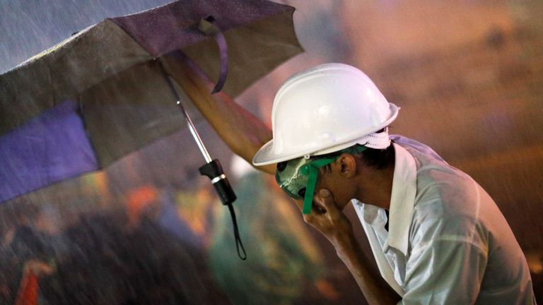 Un manifestant tient un parapluie alors qu'il se protège des canons à eau lors d'une manifestation anti-gouvernementale alors que les législateurs débattent du changement de constitution, devant le parlement à Bangkok, Thaïlande, le 17 novembre 2020. REUTERS / Jorge Silva