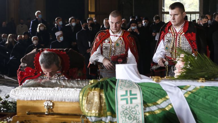 Un homme embrasse le cercueil du patriarche Irinej lors de la procession funéraire au Temple Saint Sava