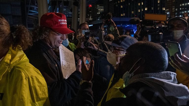 Un partisan du président américain Donald Trump s'entretient avec des manifestants de points de vue politiques différents en dehors du centre TCF où les bulletins de vote sont comptés au centre-ville de Detroit, Michigan le 4 novembre 2020. - Le challenger présidentiel démocrate Joe Biden le 4 novembre a approché le nombre magique de 270 les votes électoraux nécessaires pour gagner la Maison Blanche avec plusieurs États du champ de bataille toujours en jeu, alors que le président sortant Donald Trump a contesté le décompte des voix.  (Photo de SETH HERALD / AFP) (Photo de SETH HERALD