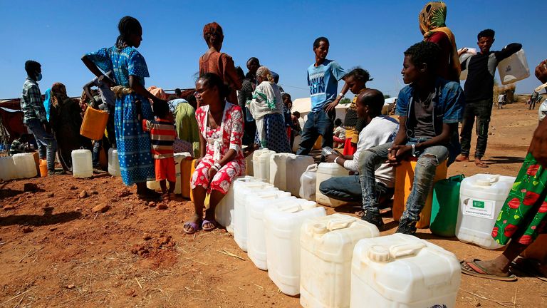 Des réfugiés éthiopiens remplissent des bouteilles et des conteneurs d'eau dans le camp d'Um Raquba au Soudan