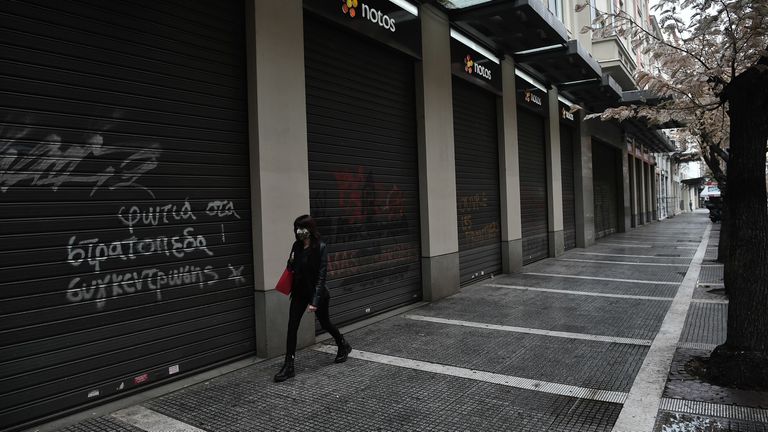Une femme portant un masque protecteur se promène à côté de magasins fermés à Thessalonique le 3 novembre 2020. - La Grèce a annoncé le 2 novembre un verrouillage de deux semaines dans sa deuxième plus grande ville de Thessalonique pour tenter de contenir un pic de cas de coronavirus.  Tout restera fermé, à l'exception des écoles, et ceux qui souhaitent quitter leur domicile devront demander l'autorisation par SMS.  (Photo par Sakis MITROLIDIS / AFP) (Photo par SAKIS MITROLIDIS / AFP via Getty Images)
