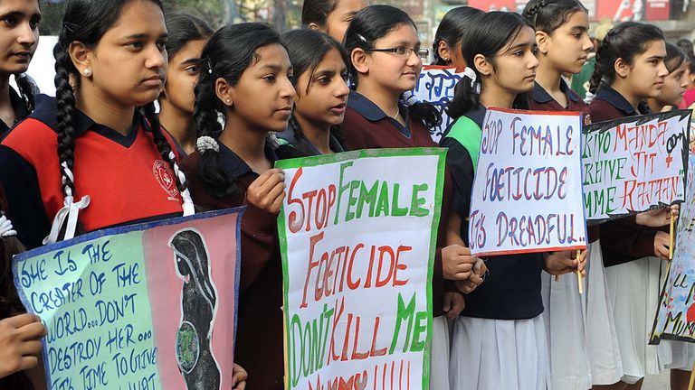 Des écolières posent avec des pancartes lors d'une marche de protestation contre le féticide féminin