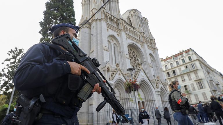Un policier armé monte la garde près de l'église Notre-Dame où l'attaque a eu lieu