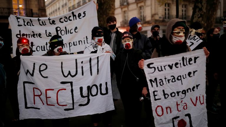 Des militants des droits masqués et des journalistes protestent alors que le parlement français débat d'un projet de loi qui érigerait en crime dans certaines circonstances une image du visage d'un policier, à Nantes, France, le 17 novembre 2020. REUTERS / Stephane Mahe / File Photo