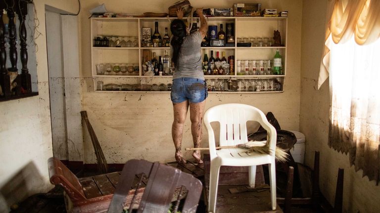 Une femme à l'intérieur d'une maison après les inondations causées par le typhon Goni a laissé de graves dégâts