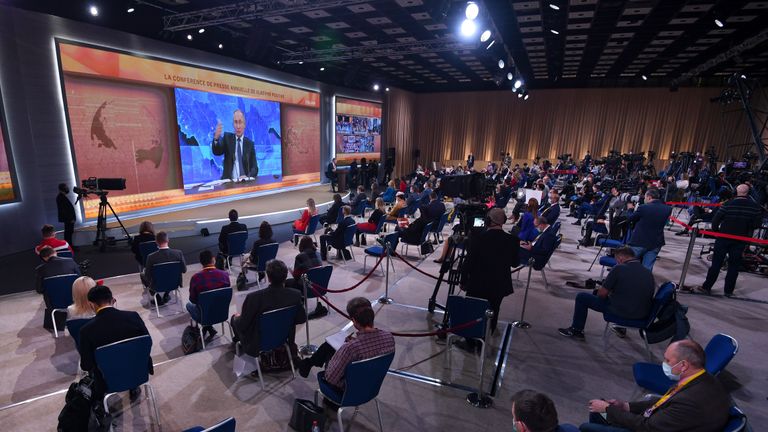 Les journalistes se rassemblent devant un écran alors qu'ils suivent le président russe Vladimir Poutine lors de sa conférence de presse annuelle via un lien vidéo depuis la résidence de l'État de Novo-Ogaryovo, au centre des congrès du World Trade Centre à Moscou le 17 décembre 2020, au milieu du coronavirus en cours. pandémie de maladie.  (Photo par NATALIA KOLESNIKOVA / AFP) (Photo par NATALIA KOLESNIKOVA / AFP via Getty Images)