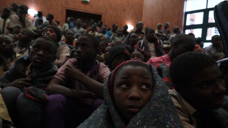 TOPSHOT - Un enfant s'enveloppe dans une couverture alors qu'il se réunissait à la maison du gouvernement avec d'autres élèves de l'école secondaire Government Science, à Kankara, dans le nord-ouest de l'État de Katsina, au Nigéria, lors de leur libération le 18 décembre 2020. - Plus de 300 écoliers nigérians étaient libérés jeudi après avoir été enlevé lors d'une attaque revendiquée par Boko Haram, ont déclaré des responsables, bien qu'il ne soit pas clair s'il en restait plus avec leurs ravisseurs (Photo de Kola SULAIMON / AFP) (Photo de KOLA SULAIMON / AFP via Getty Images)