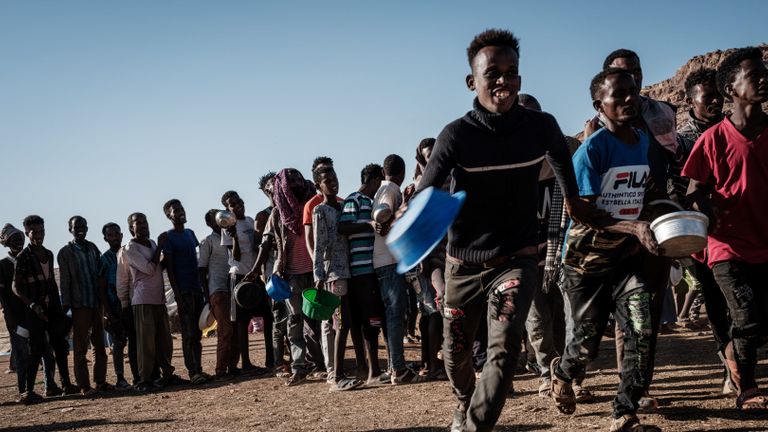 Des réfugiés éthiopiens qui ont fui le conflit éthiopien du Tigré attendent dans la file d'attente la distribution de nourriture par Muslim Aid au camp de réfugiés d'Um Raquba dans l'État soudanais de Gedaref le 12 décembre 2020 (photo de Yasuyoshi CHIBA / AFP) (photo de YASUYOSHI CHIBA / AFP via Getty Images)