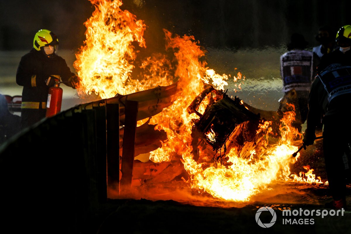 Un commissaire des incendies éteint les flammes après un énorme crash pour Romain Grosjean, Haas VF-20, dans le premier tour