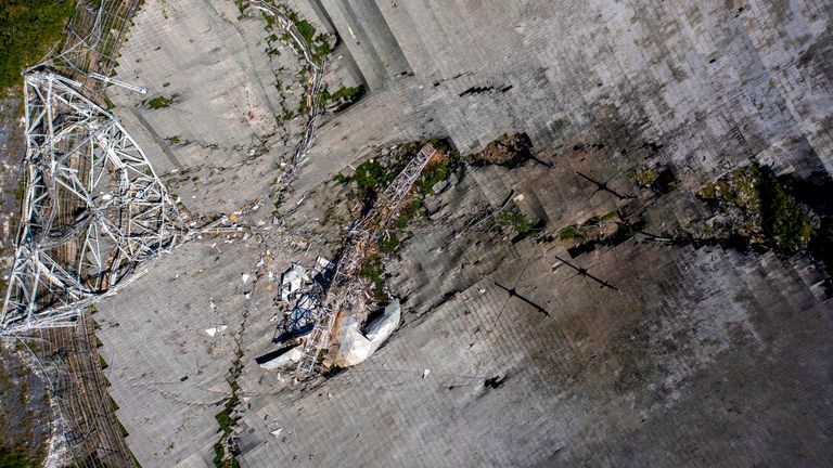 Cette vue aérienne montre les dommages à l'observatoire d'Arecibo après la rupture de l'un des principaux câbles retenant le récepteur à Arecibo, Porto Rico, le 1er décembre 2020. - Le radiotélescope de Porto Rico, qui jouait autrefois dans un film de James Bond, s'est effondré Mardi, lorsque sa plate-forme de réception de 900 tonnes a chuté de 140 mètres et s'est écrasée sur l'antenne radio ci-dessous.  (Photo de Ricardo ARDUENGO / AFP) (Photo de RICARDO ARDUENGO / AFP via Getty Images)