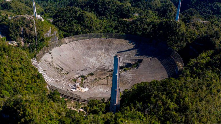 Cette vue aérienne montre les dommages à l'observatoire d'Arecibo après la rupture de l'un des principaux câbles retenant le récepteur à Arecibo, Porto Rico, le 1er décembre 2020. - Le radiotélescope de Porto Rico, qui jouait autrefois dans un film de James Bond, s'est effondré Mardi, lorsque sa plate-forme de réception de 900 tonnes a chuté de 140 mètres et s'est écrasée sur l'antenne radio ci-dessous.  (Photo de Ricardo ARDUENGO / AFP) (Photo de RICARDO ARDUENGO / AFP via Getty Images)