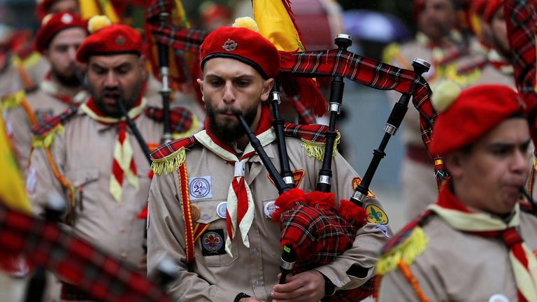 Des membres d'un groupe de scouts palestiniens se produisent devant l'église de la Nativité la veille de Noël, au milieu de l'épidémie de coronavirus (COVID-19), à Bethléem, en Cisjordanie occupée par Israël, le 24 décembre 2020. REUTERS / Mussa Qawasma