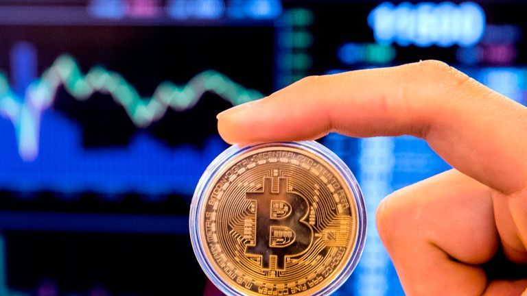 Un Israélien tient une représentation visuelle de la crypto-monnaie numérique Bitcoin, dans la boutique `` Bitcoin Change '' de la ville israélienne de Tel Aviv le 17 janvier 2018. Fin 2017, l'Autorité israélienne des valeurs mobilières a annoncé qu'elle allait interdire le commerce de la crypto-monnaie. basées sur le marché de Tel Aviv jusqu'à ce que les transactions impliquant des pièces numériques soient légalement réglementées.  / AFP PHOTO / JACK GUEZ (Le crédit photo doit se lire JACK GUEZ / AFP / Getty Images)

