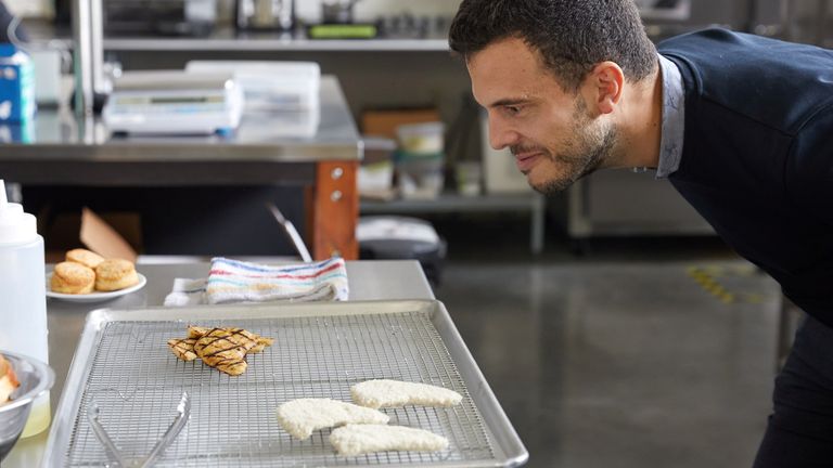 Un employé d'Eat Just regarde un filet grillé à base de poulet cultivé en laboratoire.  Pic: Mangez juste