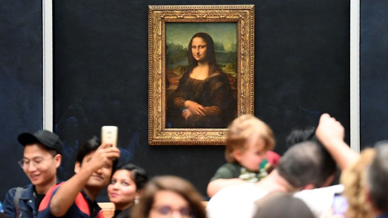 Les visiteurs prennent des photos devant Mona Lisa après son retour à sa place au musée du Louvre à Paris le 7 octobre 2019
