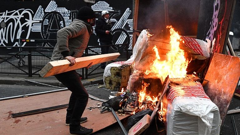 Un manifestant jette du bois sur une barricade lors de manifestations à Paris