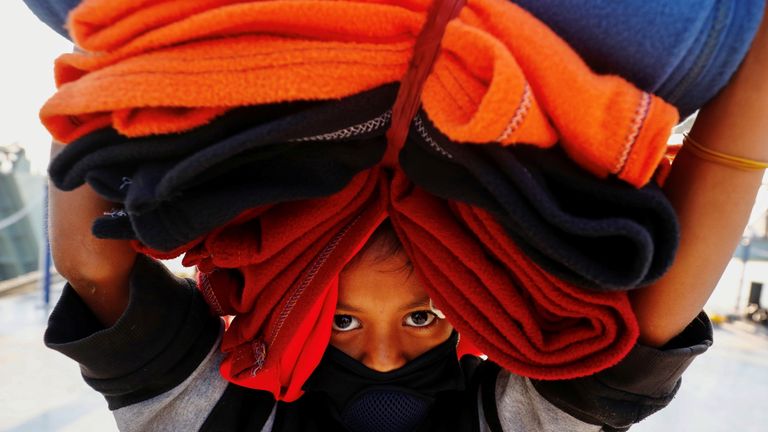 Une fille Rohingya porte des couvertures alors qu'elle se prépare à monter à bord d'un navire pour se rendre sur l'île de Bhasan Char près de Chattogram