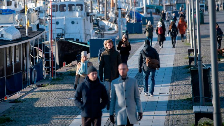 Les gens se promènent par temps froid mais ensoleillé le long du quai de Standvagen à Stockholm, en Suède, le 20 novembre 2020, au milieu de la pandémie de coronavirus en cours.  (Photo par Fredrik SANDBERG / TT News Agency / AFP) / Suède OUT (Photo par FREDRIK SANDBERG / TT News Agency / AFP via Getty Images)
