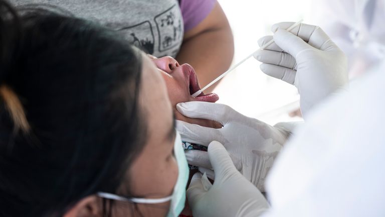 Un agent de santé effectue un test sur écouvillon Covid-19 sur un enfant avec l'aide d'adultes le 25 décembre 2020 à Bangkok, en Thaïlande.  Le nombre total d'infections confirmées à Covid-19 en Thaïlande a franchi la barre des 5000 cette semaine, à la suite d'une épidémie majeure centrée autour de la province de Samut Sakhon