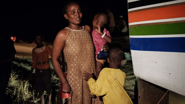 Une réfugiée éthiopienne qui a fui le conflit éthiopien du Tigré pleure à côté de ses deux enfants alors qu'elle arrive au Soudan