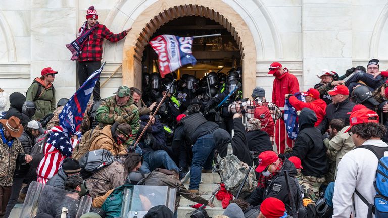 WASHINGTON DC, DISTRICT DE COLOMBIE, ÉTATS-UNIS - 2021/01/06: des émeutiers affrontent la police essayant d'entrer dans le bâtiment du Capitole par les portes d'entrée.  Les émeutiers ont brisé des fenêtres et ont violé le bâtiment du Capitole pour tenter de renverser les résultats des élections de 2020.  La police a utilisé des matraques et des grenades lacrymogènes pour finalement disperser la foule.  Les émeutiers ont également utilisé des barres de métal et des gaz lacrymogènes contre la police.  (Photo par Lev Radin / Pacific Press / LightRocket via Getty Images)