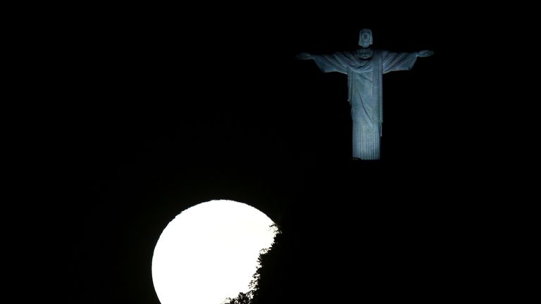 Une pleine lune illumine la statue du Christ Rédempteur à Rio de Janeiro, Brésil